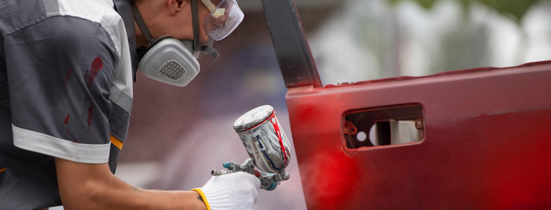 Aplicação de tinta automotiva com pistola de pulverização em oficina